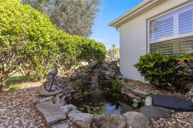 view of yard featuring a garden pond