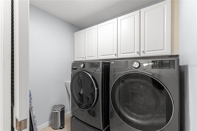 clothes washing area with cabinets and independent washer and dryer