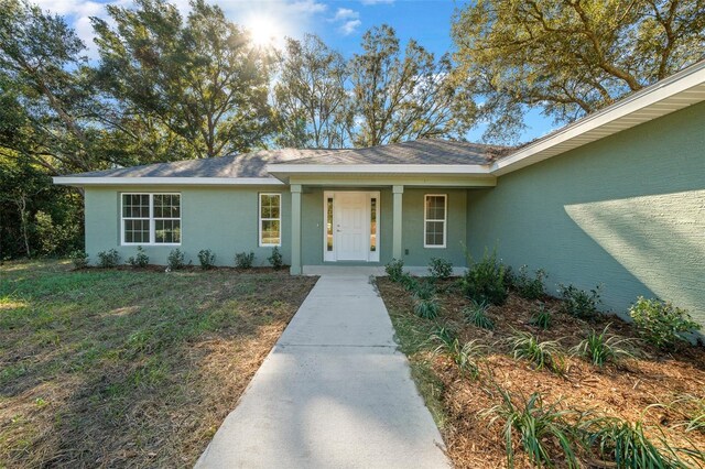 19662 SW Marine Blvd, Dunnellon, FL 34431 - property entrance with stucco siding, a porch, and a yard
