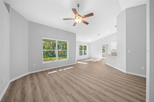 unfurnished living room with light hardwood / wood-style floors, ceiling fan, and lofted ceiling