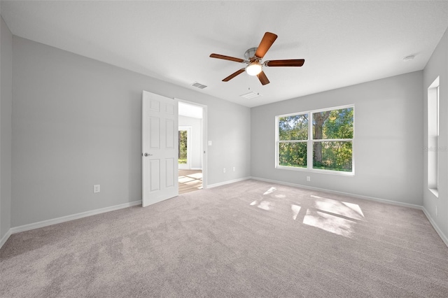 spare room with ceiling fan and light carpet