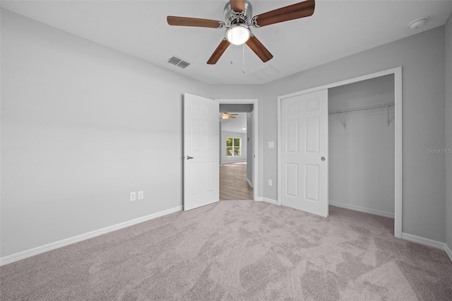 unfurnished bedroom featuring ceiling fan, a closet, and light colored carpet