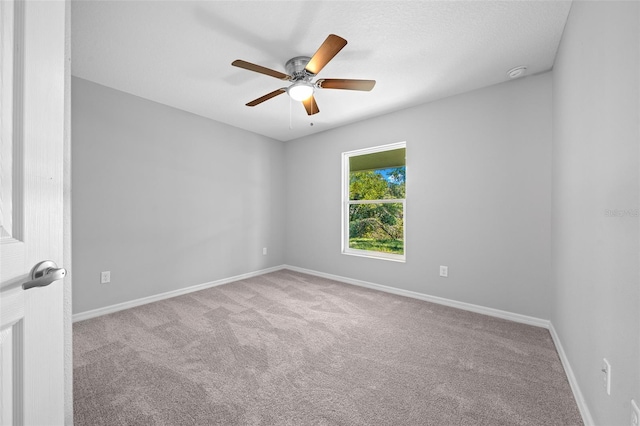 carpeted spare room featuring ceiling fan