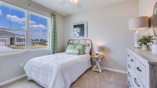 bedroom with baseboards, ceiling fan, and light carpet