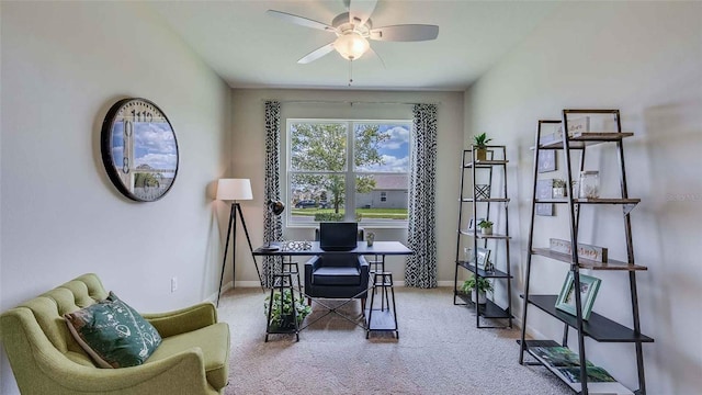 carpeted home office featuring baseboards and ceiling fan