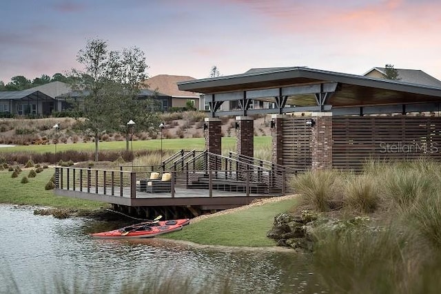 surrounding community featuring a deck with water view
