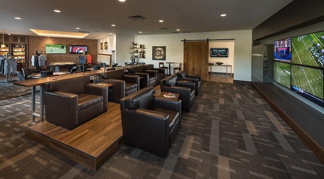 home theater featuring a barn door and dark colored carpet