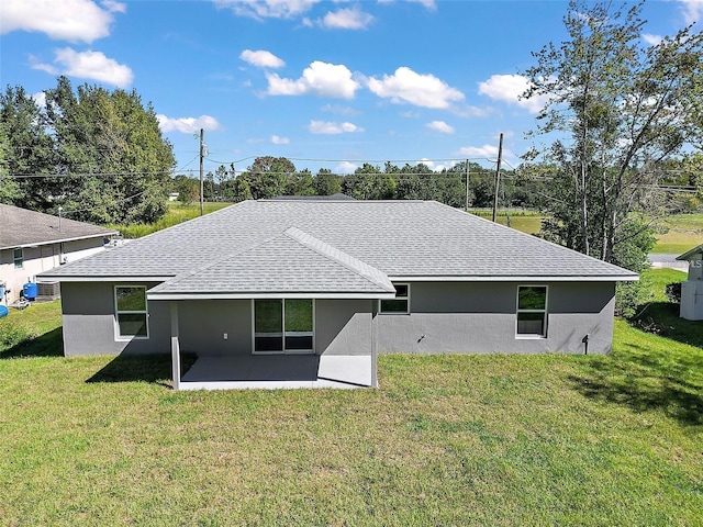 rear view of house featuring a patio and a lawn