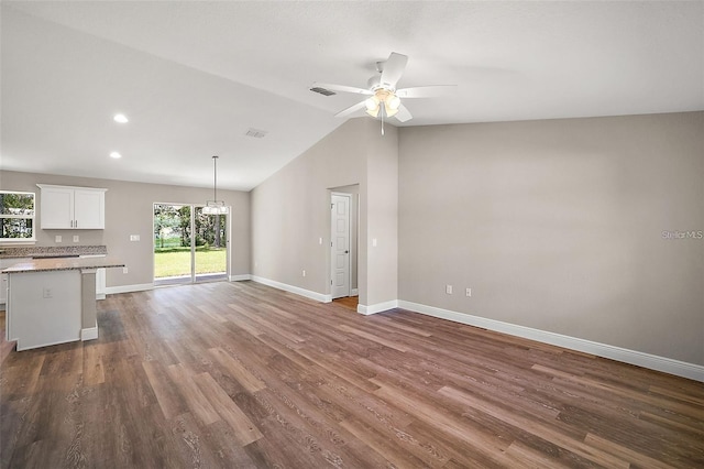 unfurnished living room featuring dark wood-type flooring, ceiling fan, and vaulted ceiling