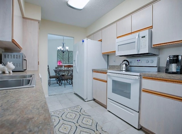 kitchen with sink, pendant lighting, a chandelier, white cabinetry, and white appliances