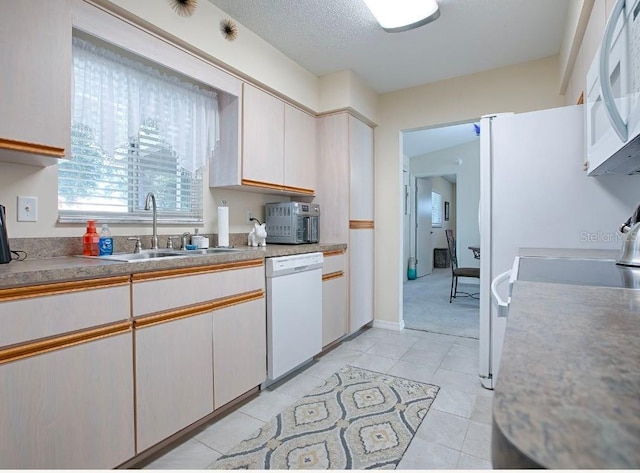 kitchen featuring light tile patterned flooring, white cabinetry, sink, and white appliances