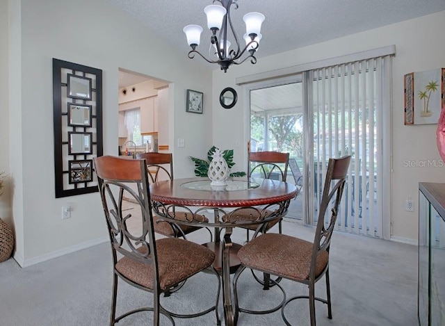 dining space with light colored carpet, a textured ceiling, and a chandelier