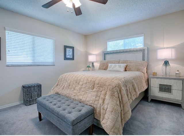 bedroom with ceiling fan, carpet flooring, and a textured ceiling