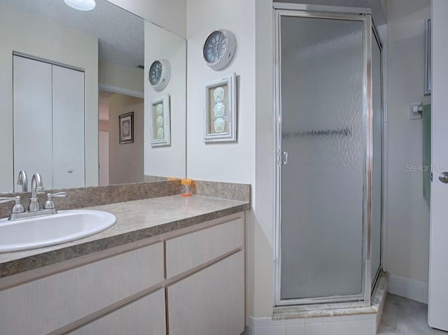 bathroom with vanity, tile patterned floors, a textured ceiling, and a shower with shower door