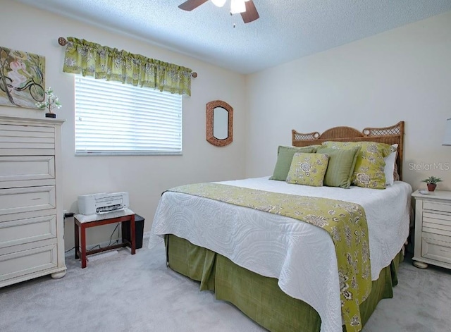 bedroom with a textured ceiling, carpet flooring, and ceiling fan