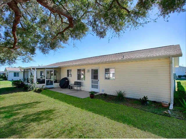 rear view of house featuring a patio, a sunroom, and a lawn