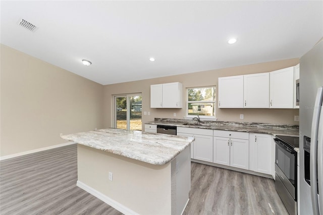 kitchen with white cabinetry, stainless steel appliances, and a center island