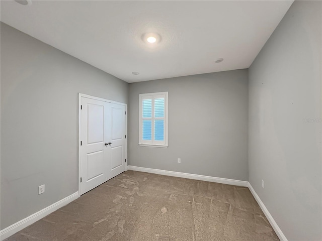 unfurnished bedroom with baseboards and carpet floors