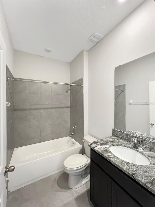 full bathroom with toilet, tiled shower / bath combo, vanity, and tile patterned floors