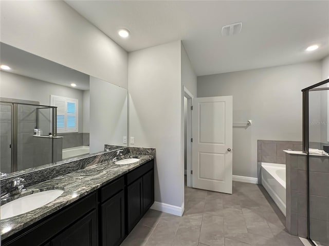 bathroom featuring a garden tub, a stall shower, and a sink