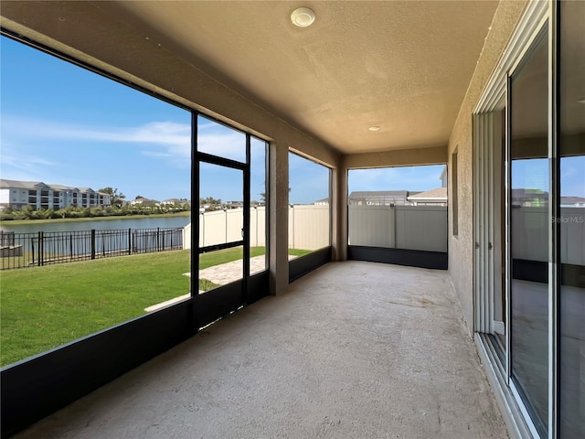 unfurnished sunroom featuring a water view