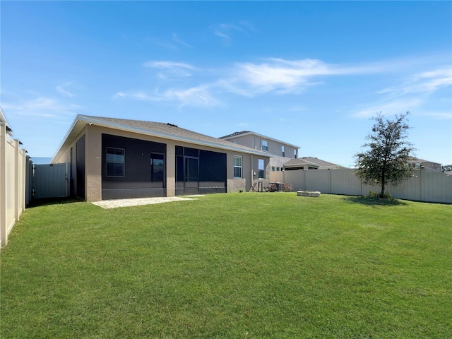 back of house featuring stucco siding, a lawn, and a fenced backyard