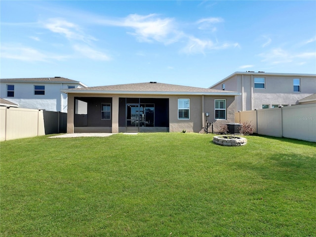 back of property with a patio, central AC, a fire pit, and a lawn