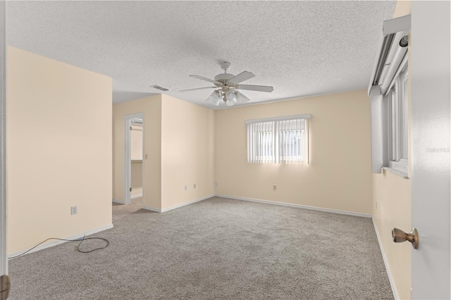 carpeted empty room featuring ceiling fan and a textured ceiling