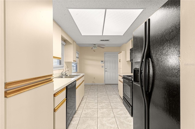 kitchen featuring ceiling fan, sink, black appliances, light tile patterned floors, and white cabinetry