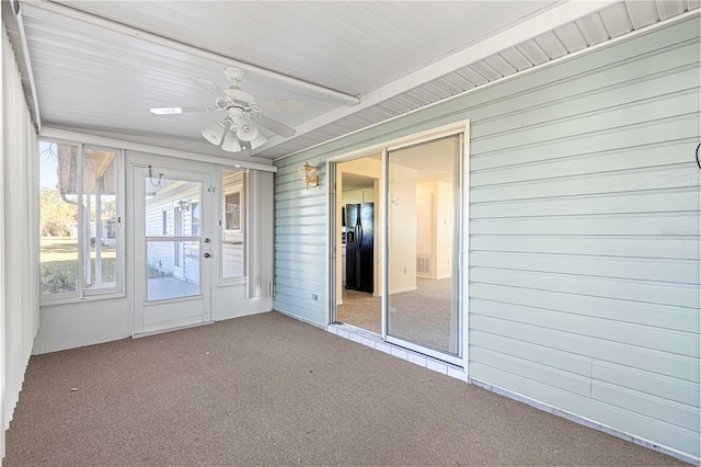 unfurnished sunroom with ceiling fan and beamed ceiling