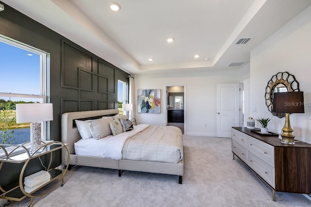 carpeted bedroom featuring multiple windows and a raised ceiling