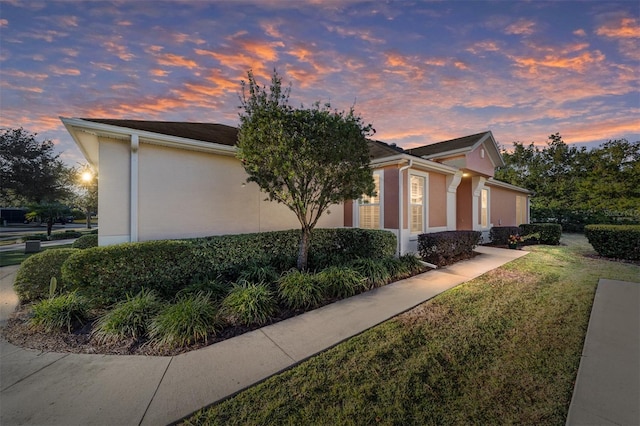 view of front of home with a garage and a lawn