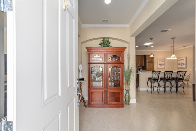 foyer featuring ornamental molding and light tile patterned floors