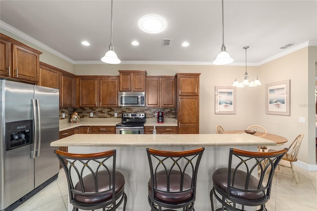 kitchen with an island with sink, backsplash, hanging light fixtures, stainless steel appliances, and ornamental molding