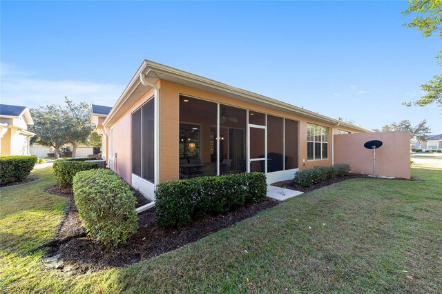 back of house featuring a yard and a sunroom