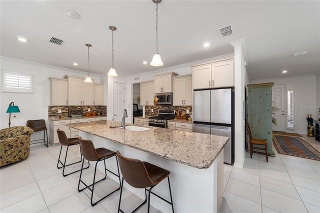 kitchen featuring a kitchen breakfast bar, stainless steel appliances, sink, and an island with sink