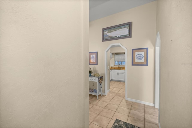 corridor with sink and light tile patterned flooring