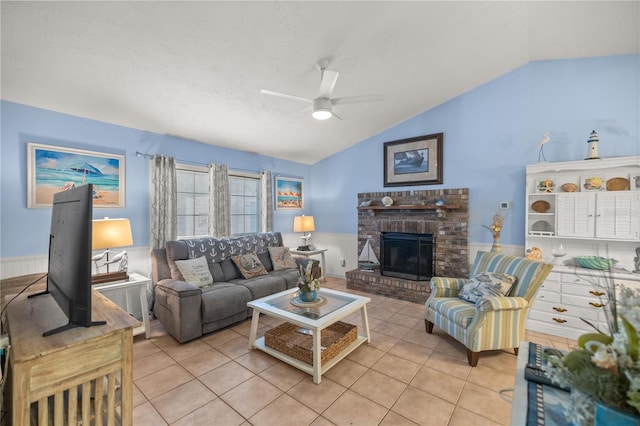 living room with a fireplace, ceiling fan, vaulted ceiling, and light tile patterned floors