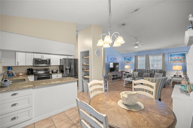 tiled dining area with ceiling fan with notable chandelier and sink