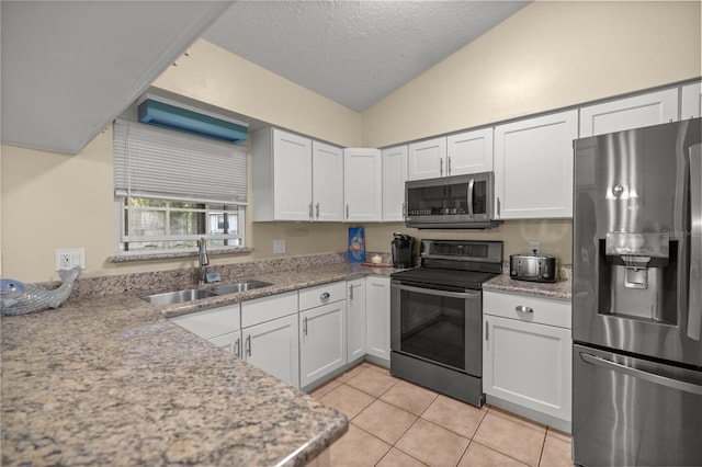 kitchen with light tile patterned flooring, white cabinetry, sink, and appliances with stainless steel finishes