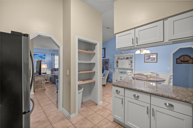 kitchen featuring built in shelves, white cabinetry, stainless steel refrigerator, and light tile patterned flooring