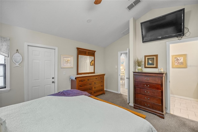 bedroom featuring ceiling fan, lofted ceiling, dark carpet, and ensuite bathroom