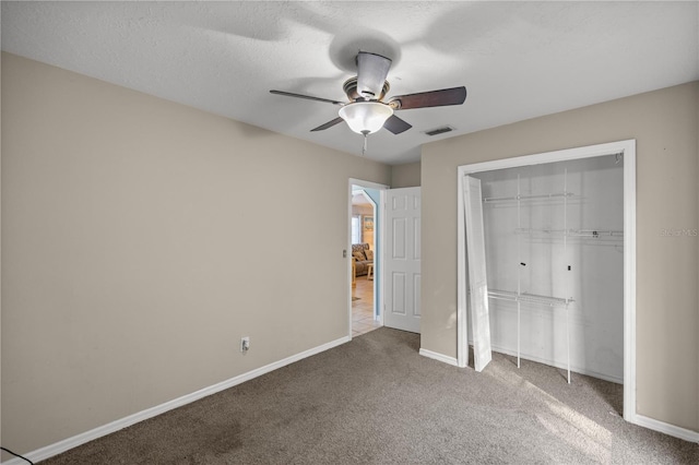 unfurnished bedroom with a closet, carpet, a textured ceiling, and ceiling fan