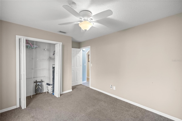 unfurnished bedroom featuring carpet flooring, a textured ceiling, ceiling fan, and a closet