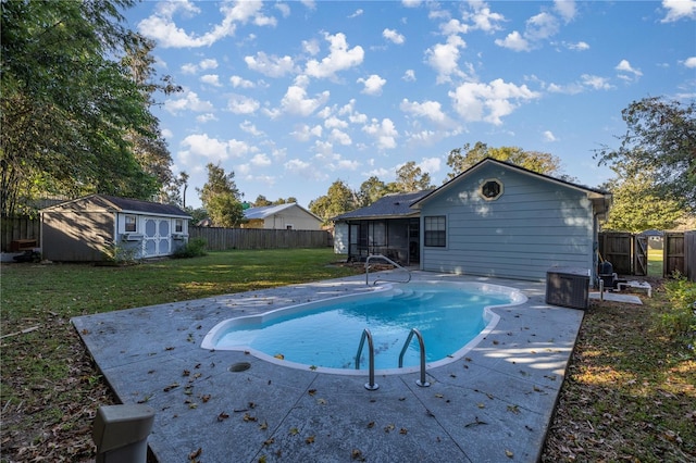 view of pool featuring a patio, a lawn, a sunroom, and a storage shed