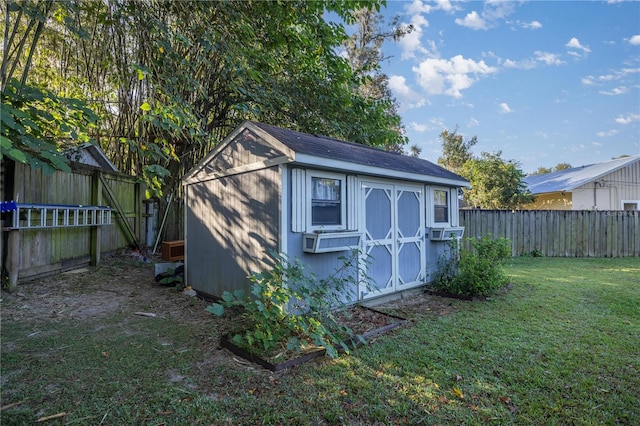 view of outbuilding featuring cooling unit and a lawn