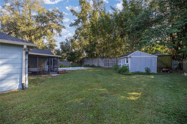 view of yard with a sunroom and a storage shed