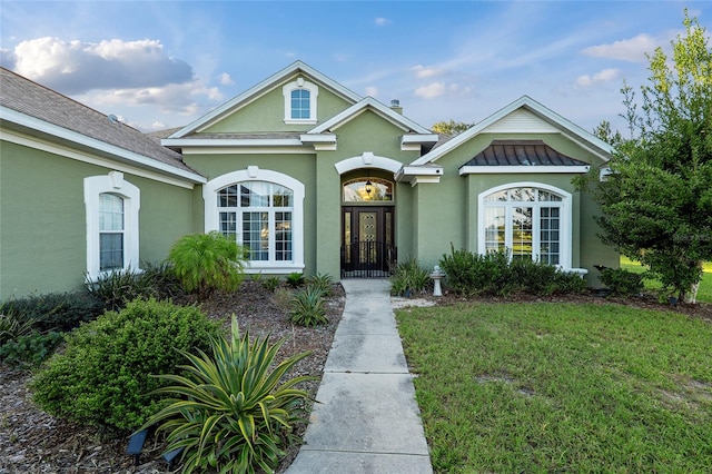 view of front of house with french doors and a front lawn