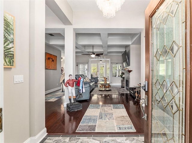 foyer with dark wood-type flooring, coffered ceiling, beamed ceiling, and ceiling fan with notable chandelier