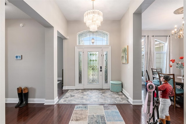 foyer entrance featuring an inviting chandelier and dark hardwood / wood-style floors